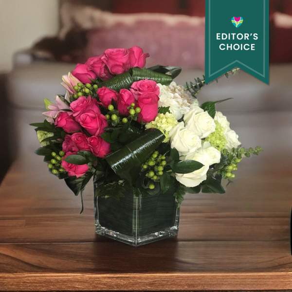 Pink and white rose bouquet in a square glass vase