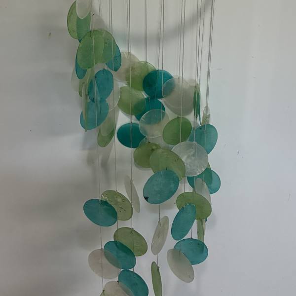Hanging mobile with teal, green, and white discs on strings from a bamboo ring