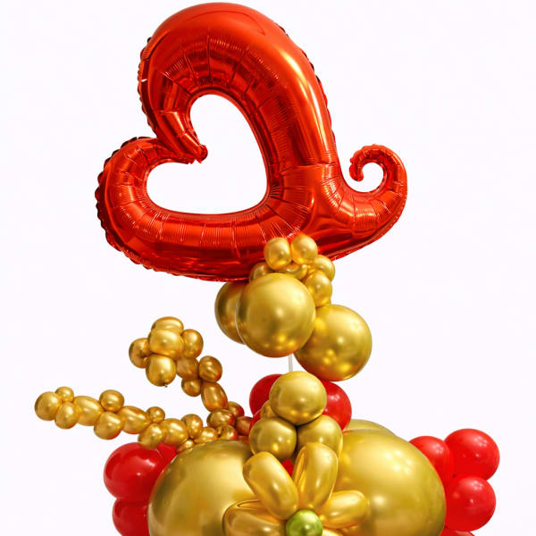 Red and gold balloon arrangement with a heart-shaped balloon topper