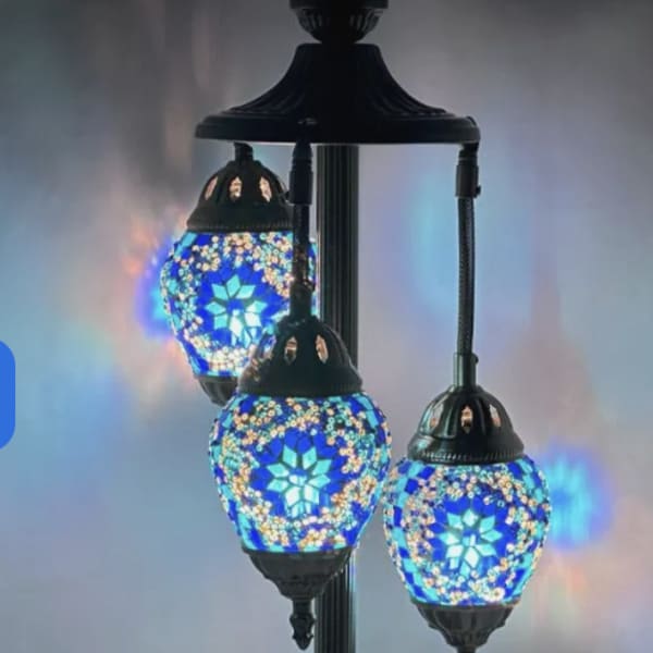 Three mosaic glass table lamps with blue light on a metal stand