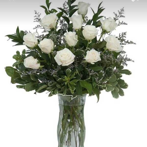 White roses arranged in a clear glass vase