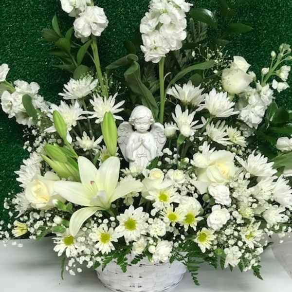 White floral basket with lilies, daisies, and an angel figurine