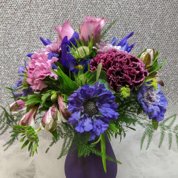 Purple and pink mixed bouquet in a purple vase