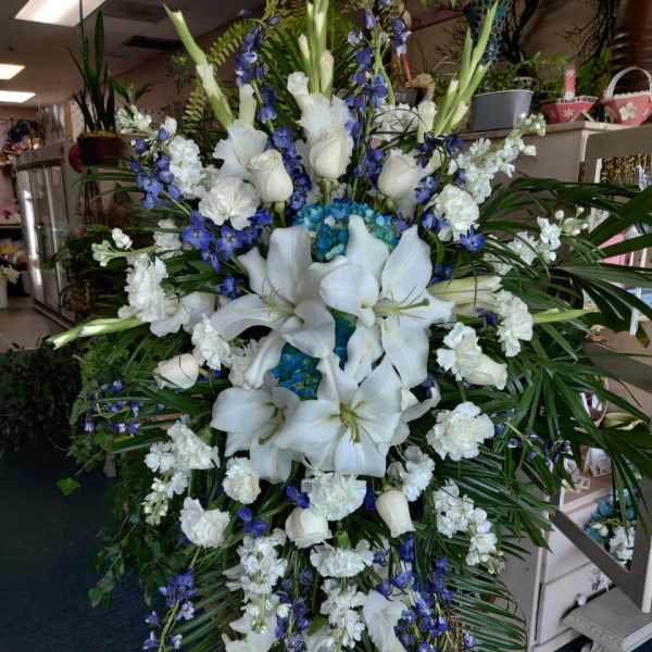 Large white and blue funeral spray with lilies and orchids