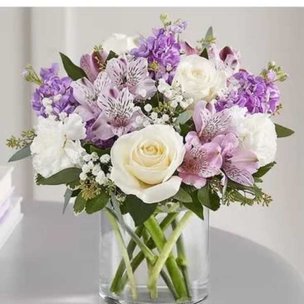 Bouquet of white and lavender flowers in a clear glass vase