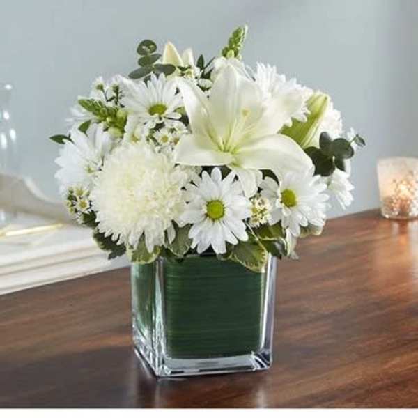 White floral arrangement in a square glass vase