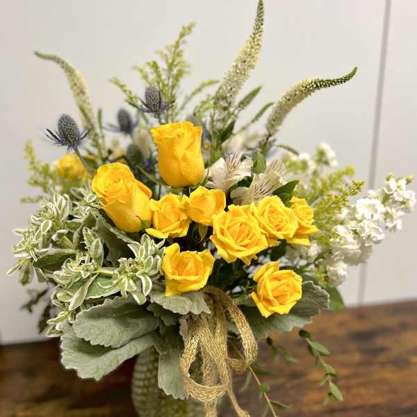 Yellow roses in a vase with white and green accents