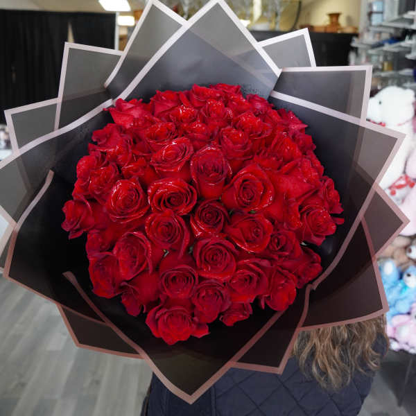 Large bouquet of red roses wrapped in black paper