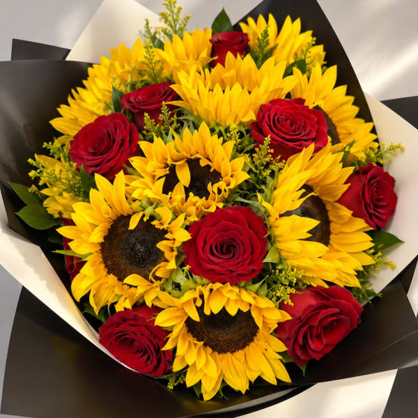 Bouquet of red roses and yellow sunflowers wrapped in black paper