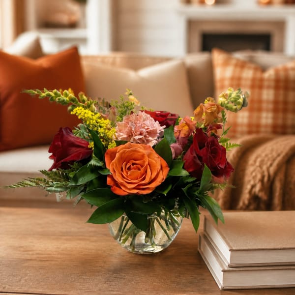 Mixed bouquet of roses and carnations in a clear glass vase