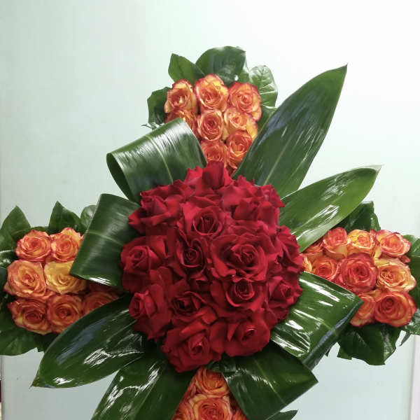 Cross-shaped floral arrangement of red and orange roses