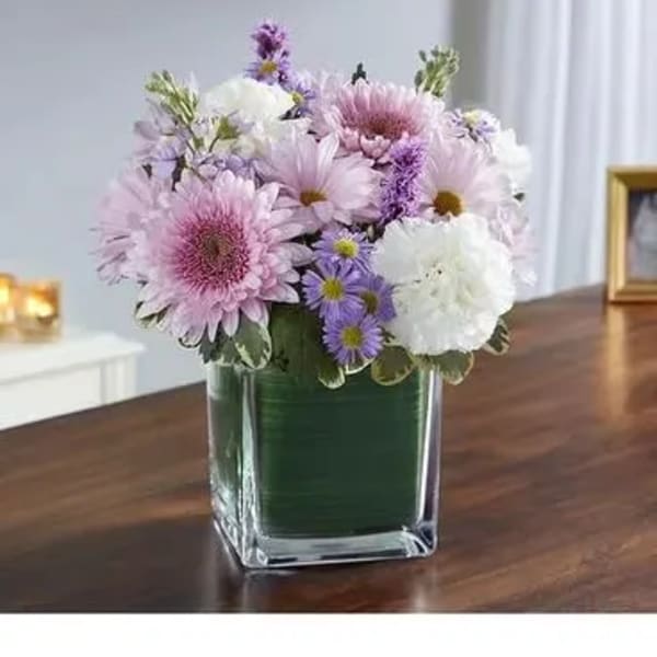 Pink and white daisy bouquet in a square glass vase