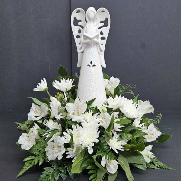 White angel figurine above a low arrangement of white flowers