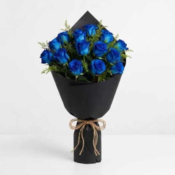 Bouquet of blue roses wrapped in black paper with a twine bow