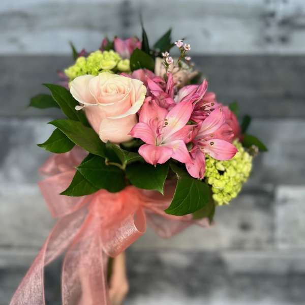 Pink rose bouquet with alstroemeria and green hydrangeas tied with a pink ribbon