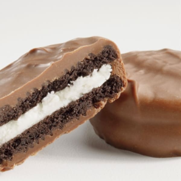Chocolate-covered sandwich cookie with cream filling, one cookie cut open