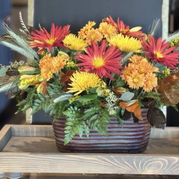 Autumn flower arrangement in a ribbed brown container