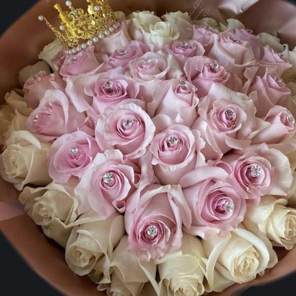 Round bouquet of pink and cream roses with crystal centers and a small gold crown on top