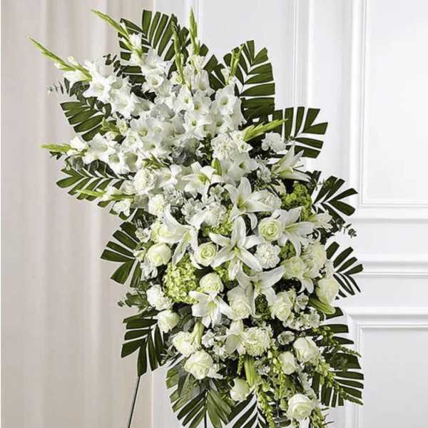 White floral standing spray with lilies and roses on a display easel