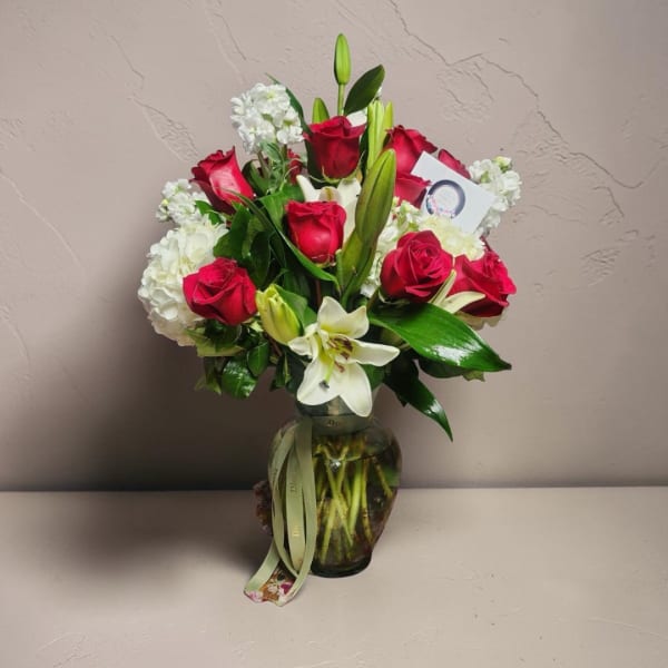 Red roses and white lilies arranged in a glass vase