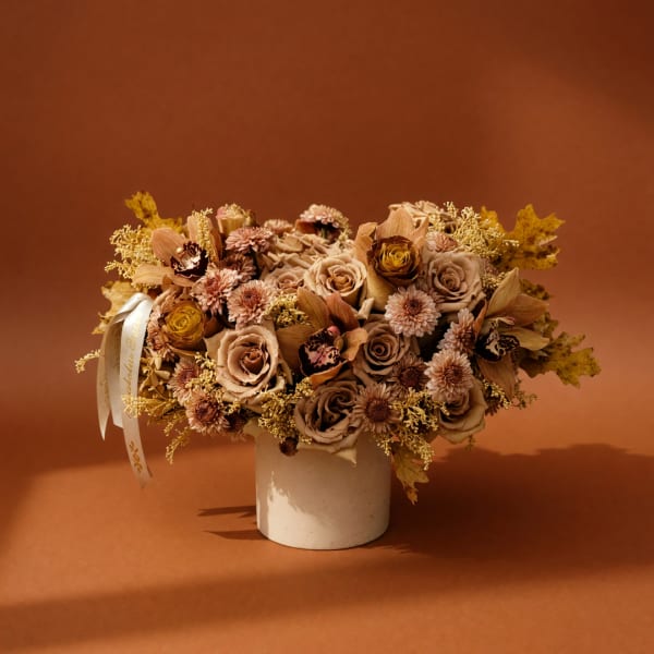 Bouquet of beige and blush flowers in a white vase with a ribbon