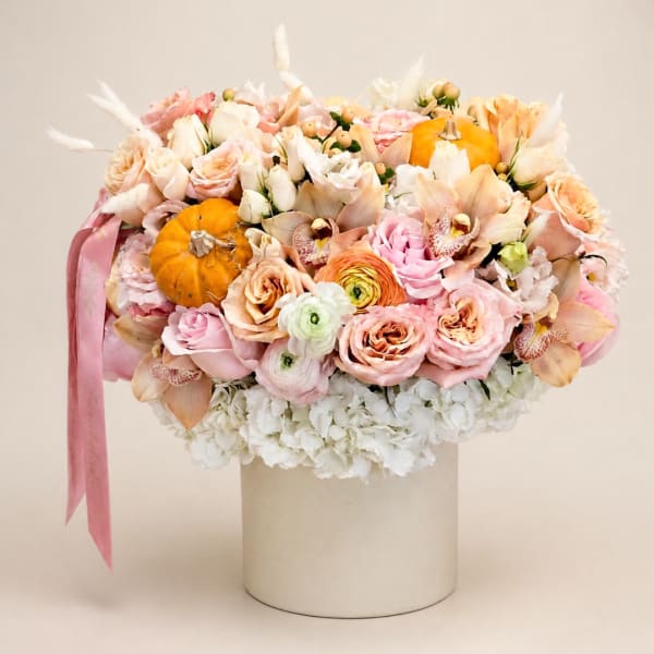 Pastel bouquet with roses, orchids, and small pumpkins in a white hat box