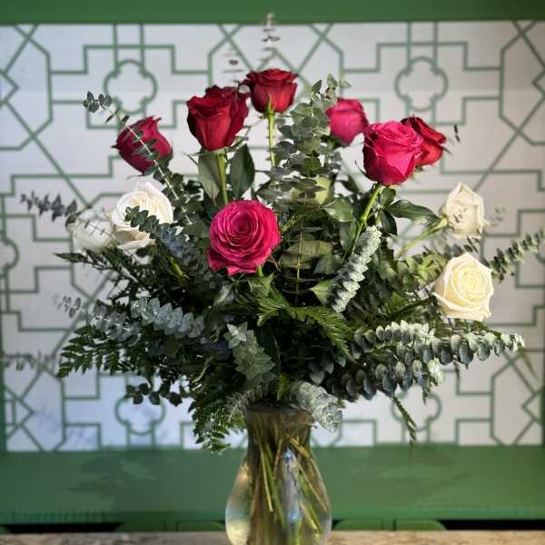 Bouquet of red, pink, and white roses in a glass vase