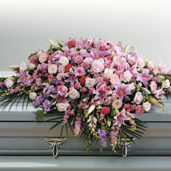 Pink and white floral casket spray with lilies and roses