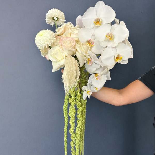 White orchid and rose bouquet with long green hanging accents