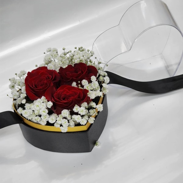 Red roses in a heart-shaped box with white baby's breath