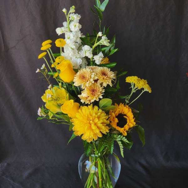 Yellow and white mixed bouquet in a clear glass vase