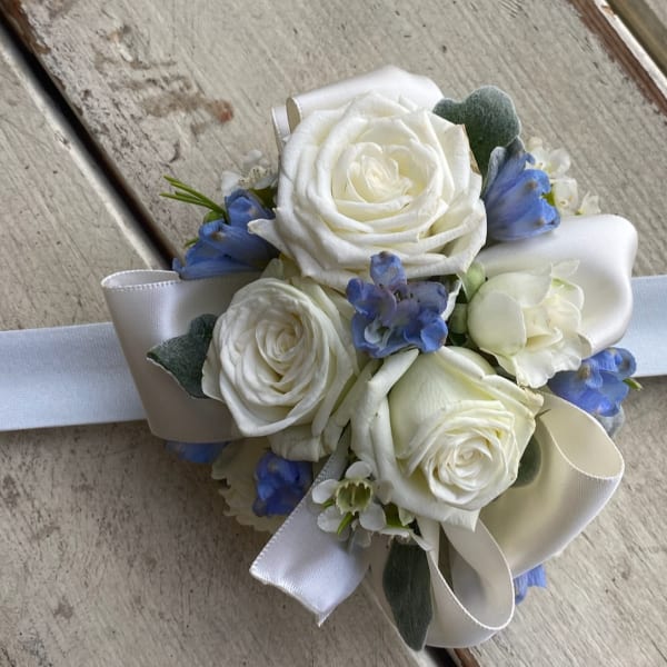 White rose wrist corsage with blue accents and white ribbon