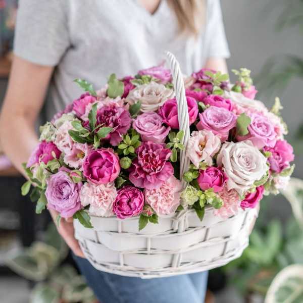 Basket of pink and lavender roses and carnations