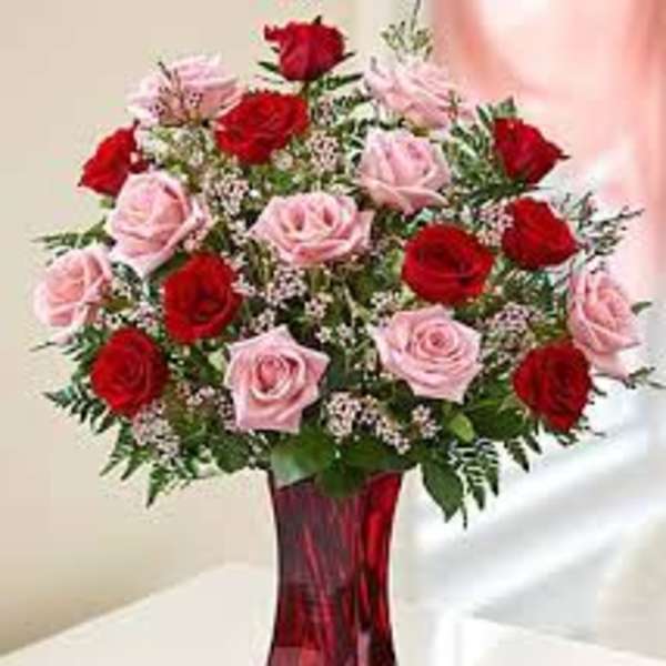 Bouquet of red and pink roses in a red glass vase