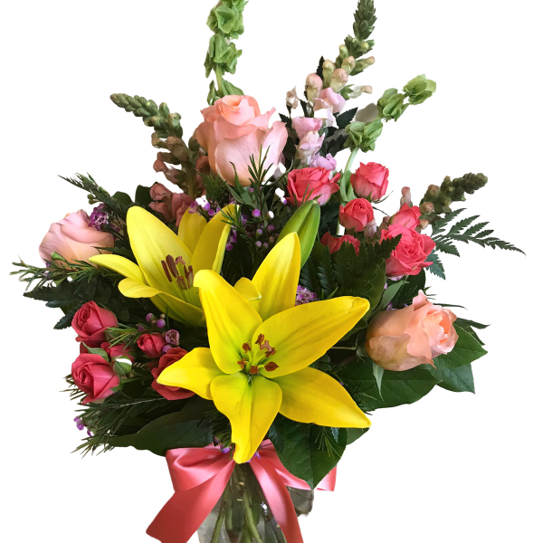 Bouquet of yellow lilies and pink roses in a glass vase with a pink ribbon