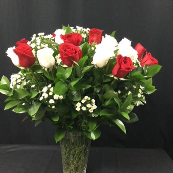 Red and white roses arranged in a clear glass vase