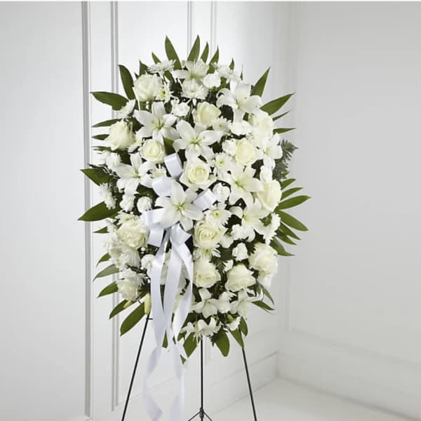 White funeral wreath on a stand with ribbon