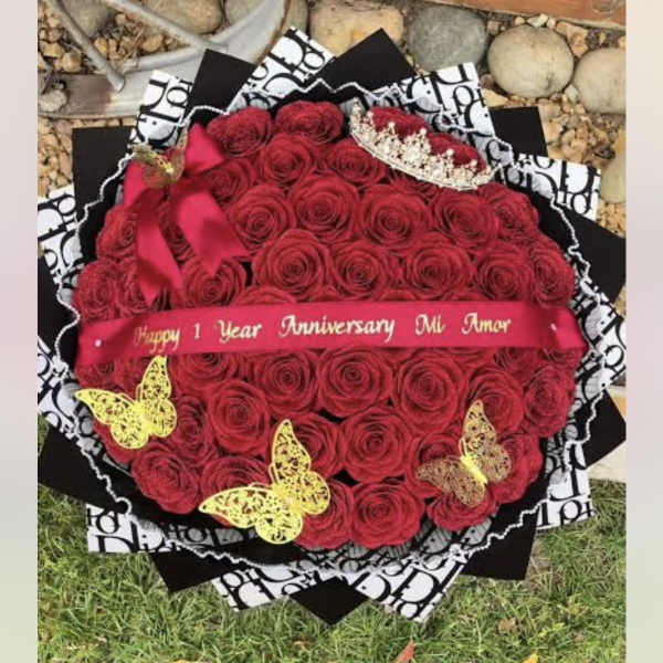 Heart-shaped bouquet of red roses with a pink ribbon and butterfly decorations