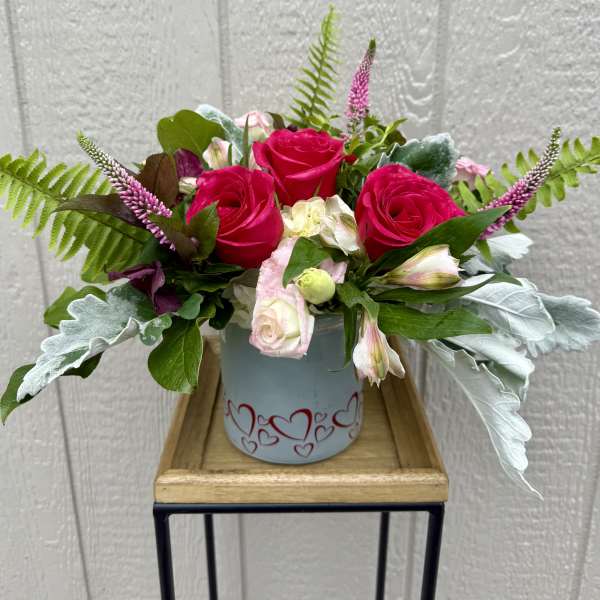 Pink roses and pale alstroemeria in a heart-decorated vase