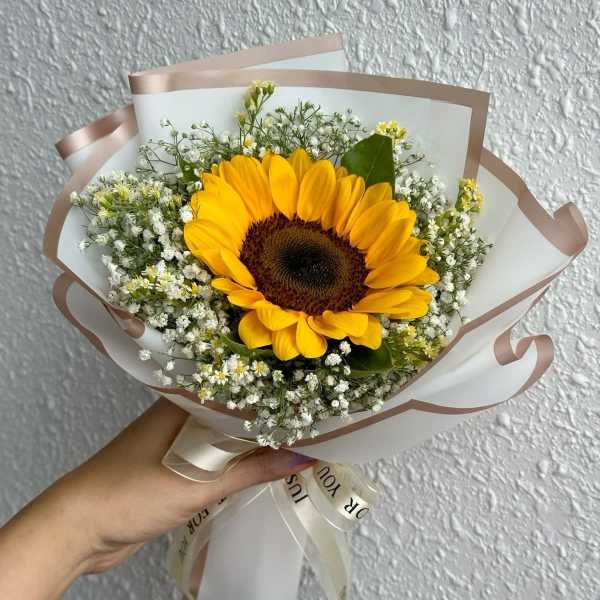 Handheld bouquet with a sunflower and small white filler flowers