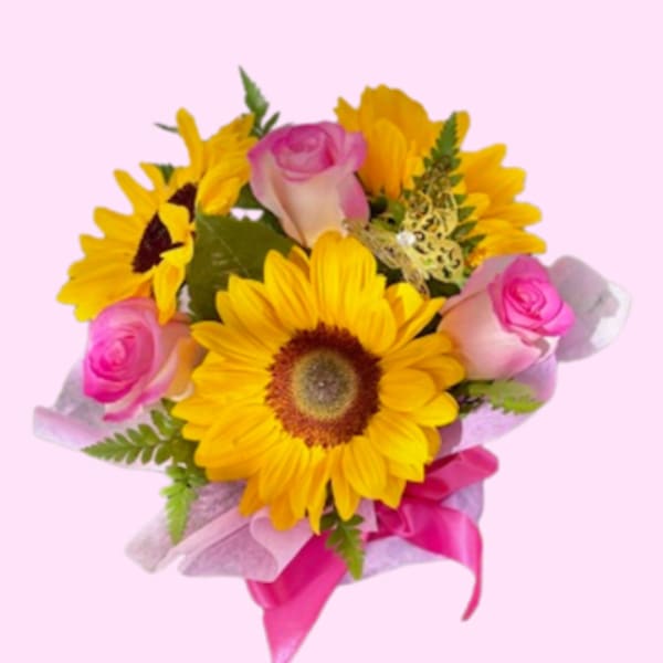 Bouquet of yellow sunflowers and pink roses with a pink ribbon
