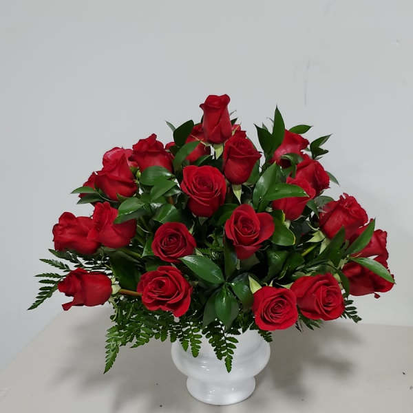 Red roses arranged in a white vase