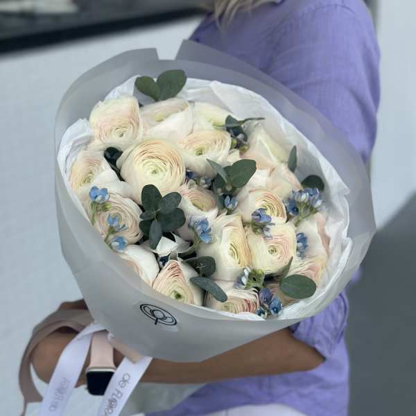 Bouquet of pale ranunculus with blue accents and eucalyptus