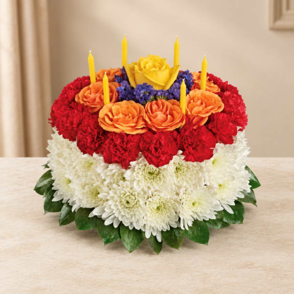 Round floral arrangement with candles in red, orange, yellow, and white