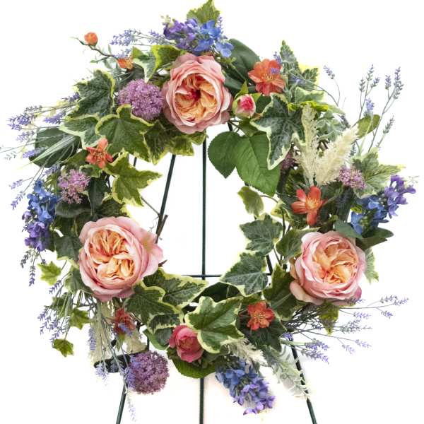 Floral wreath with pink roses, purple blooms, and mixed greenery