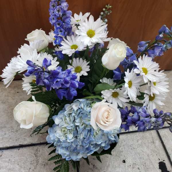 Bouquet of white roses, blue hydrangea, and white daisies with purple flowers