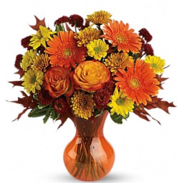 Orange and yellow mixed bouquet in an amber glass vase