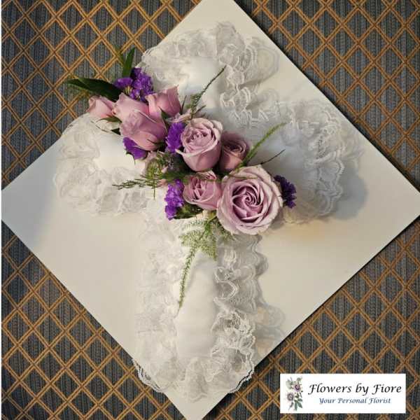 Lavender roses and purple flowers arranged on white lace ribbon