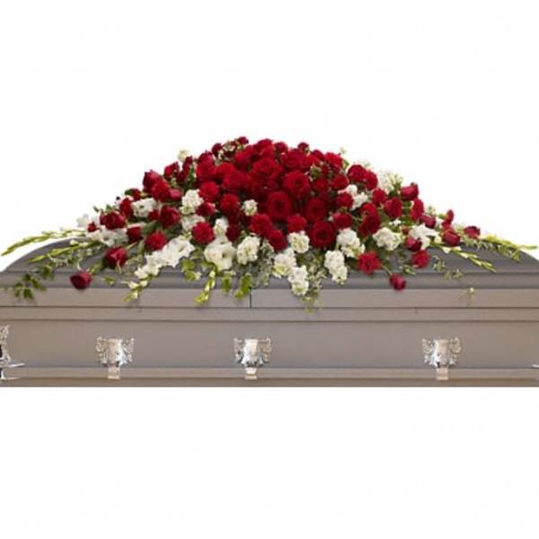Red and white floral casket spray on a gray casket