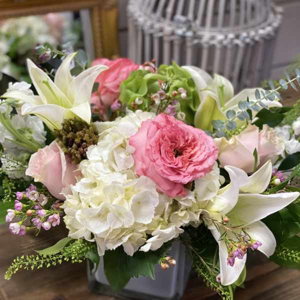 Pink and white floral arrangement in a gray vase